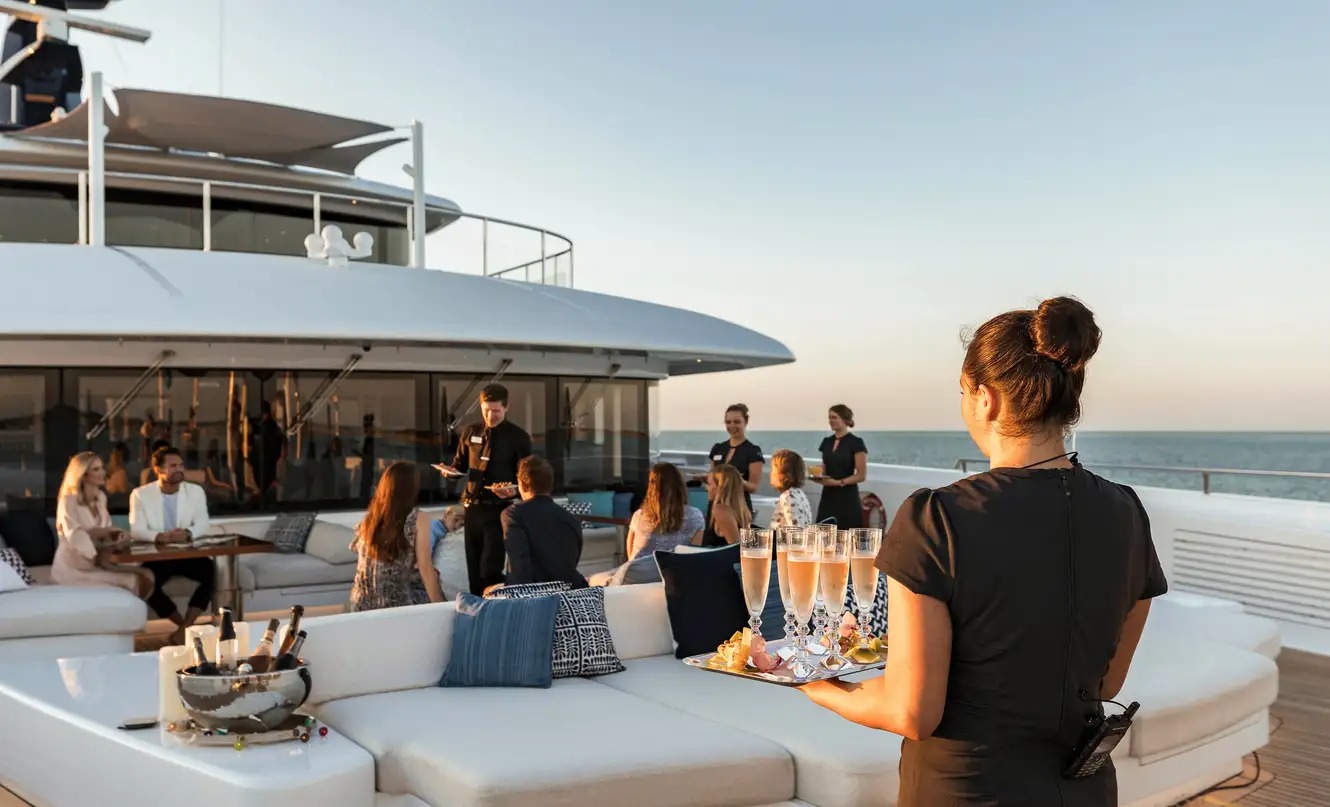 Guests gathering on a superyacht deck at sunset